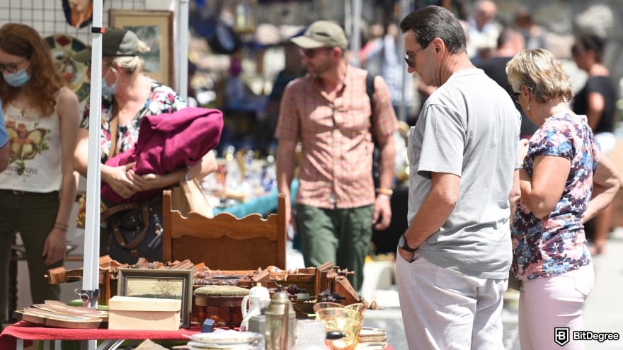 How to withdraw money from OKX in India: people browsing items at a flea market. How to withdraw money from OKX in India: people browsing items at a flea market.