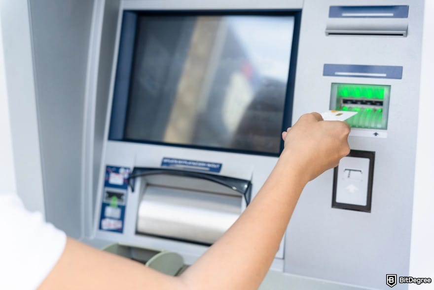 How to withdraw money from PayPal: a person inputting their ATM card.