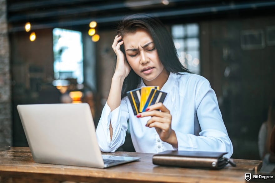 How to withdraw money from PayPal: a woman holding debit cards, looking frustrated.