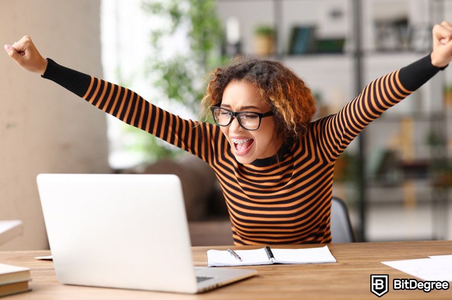 How to withdraw USDT to bank account: a happy woman looking at a laptop.