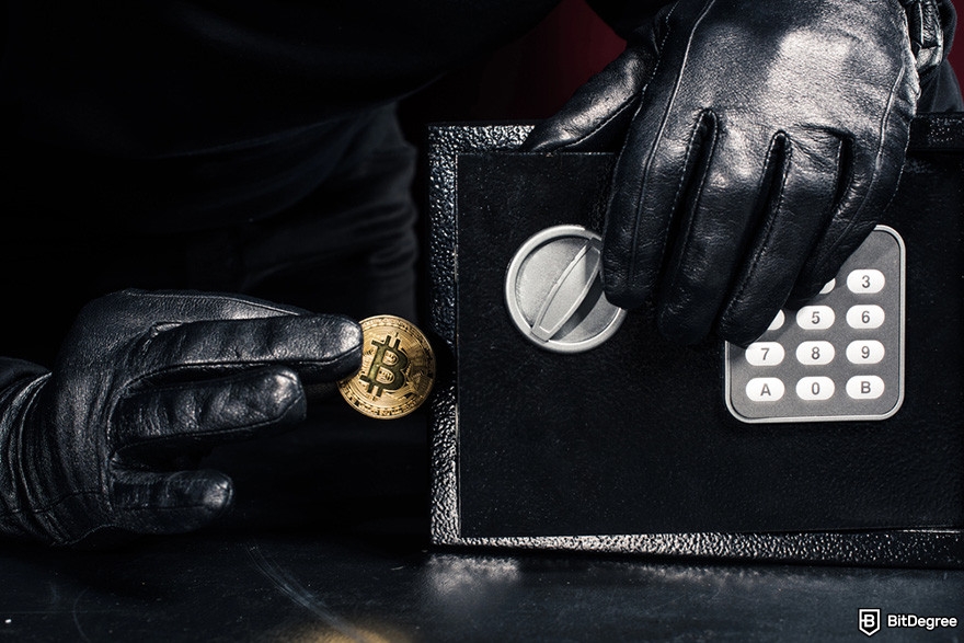 Indodax review: a person wearing black leather gloves picking a BTC coin from a safe.