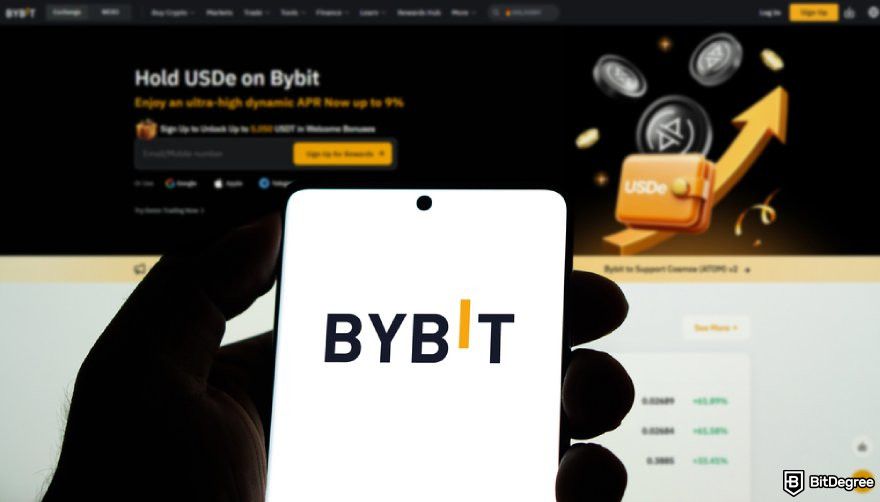 Is Bybit safe: a hand holding a phone displaying Bybit's logo.