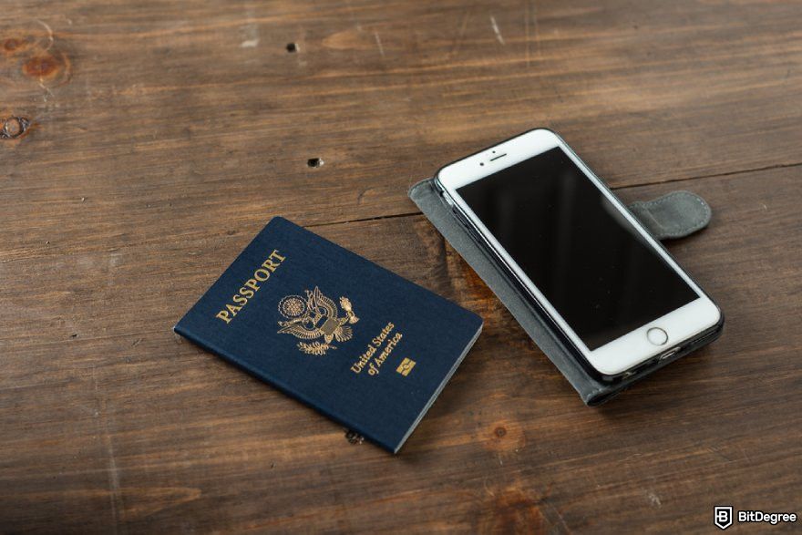 Is Bybit safe: a mobile phone and a US passport on a wooden surface.