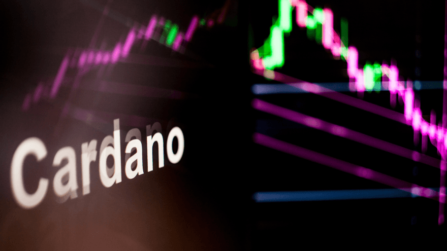 Is Cardano dead: a digital screen with the word "Cardano" alongside a candlestick chart.