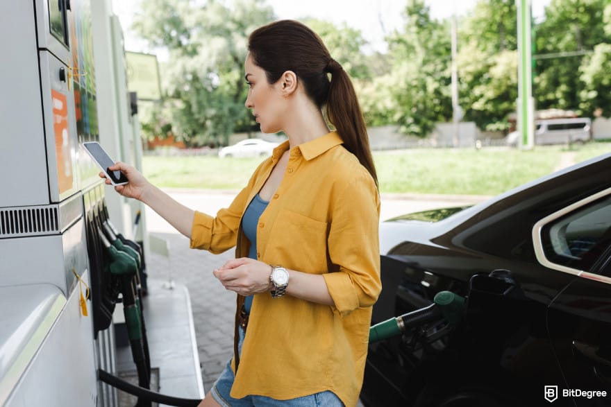 Is Ethereum dead: woman paying for gas at a fuel station.