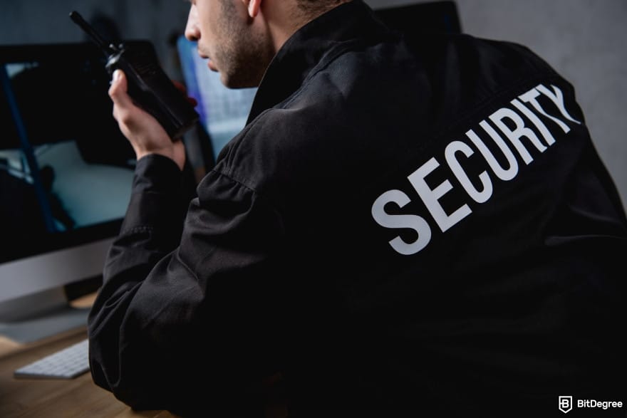 Is Kraken safe: a security guard in uniform holding walkie-talkie.