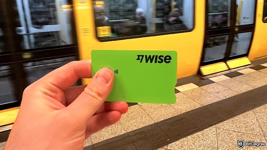 Is Wise available in Pakistan: a person holding a Wise Card in a train station.