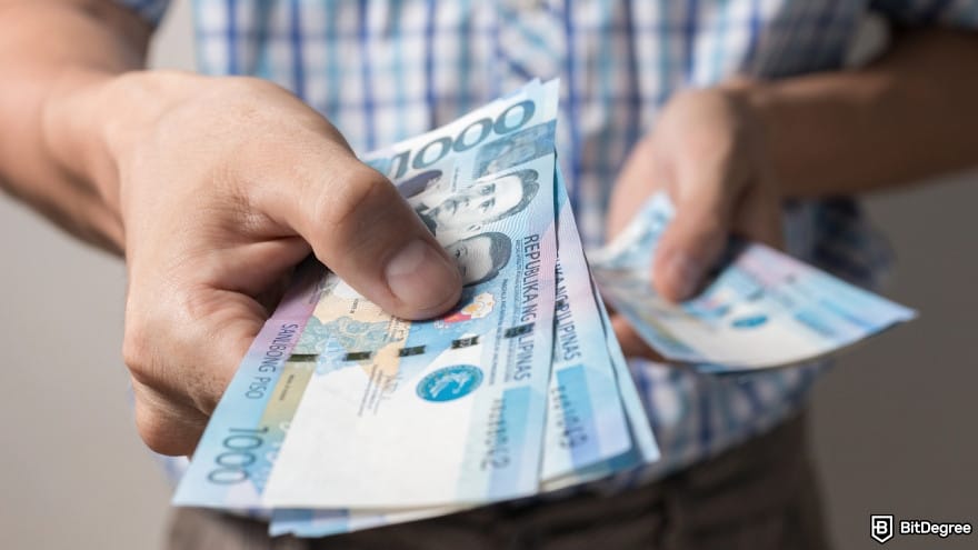 Is Wise available in the Philippines: a person holding Philippines peso banknotes.