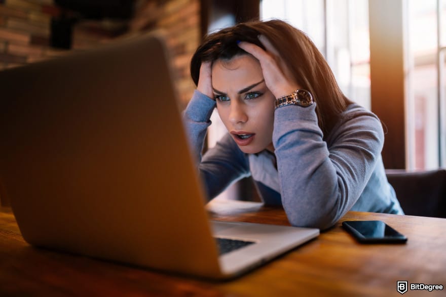 KuCoin KYC requirements: a frustrated woman staring at her laptop screen