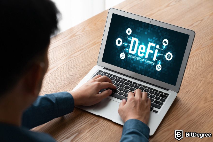 Lido staking: a person typing on a laptop showing DeFi on screen.