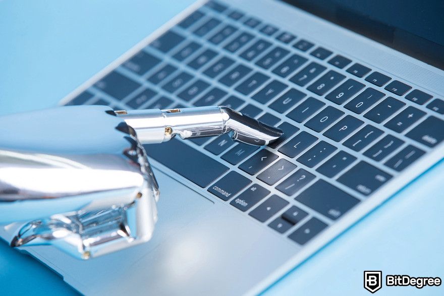 Machine learning vs AI: robot hand pressing laptop button.