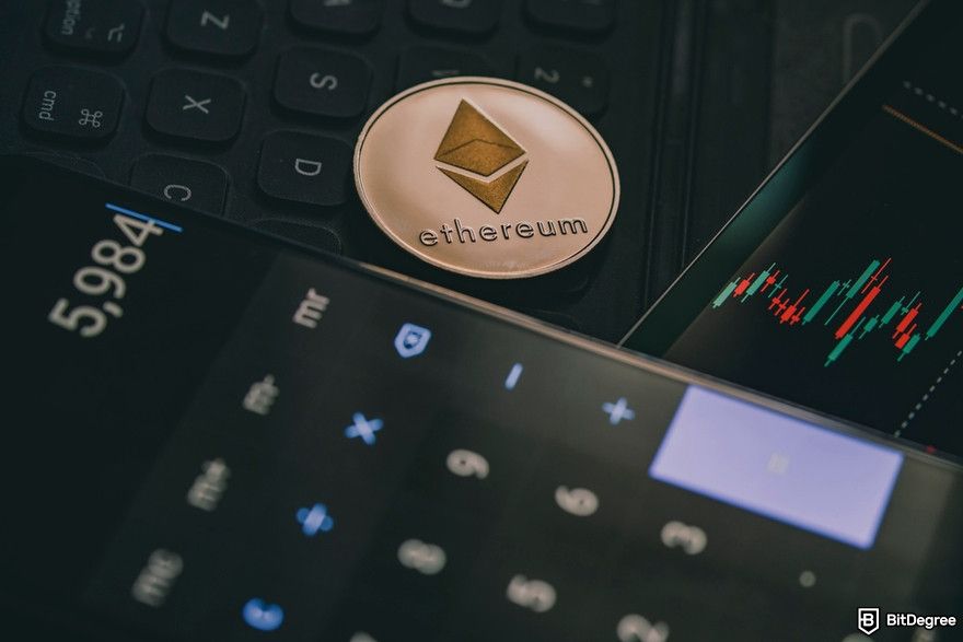 Managing multiple crypto wallets: a close-up of Ethereum physical coin and a calculator app on a smartphone.