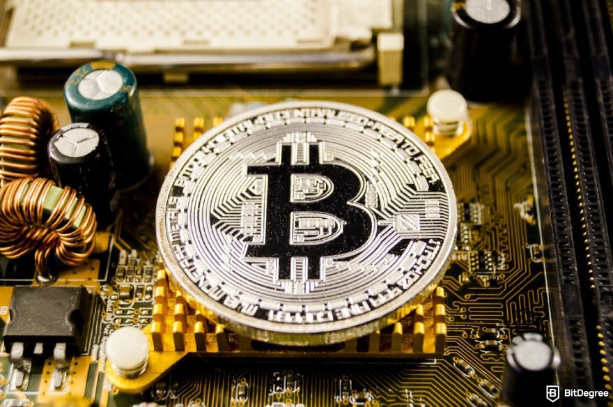 MetaMask review: a Bitcoin coin sits on a computer motherboard.