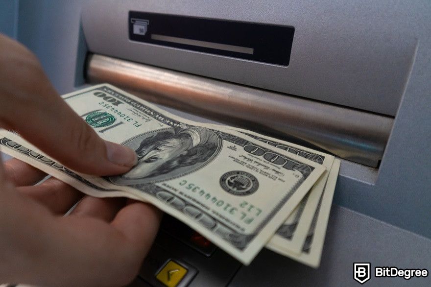 Đào tiền ảo trên điện thoại: một người đang rút tiền từ máy ATM.