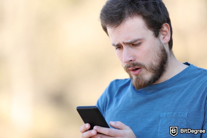 Minerar criptomoeda no celular: homem confuso verificando smartphone.