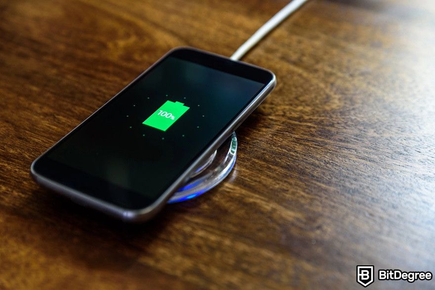 Mining cryptocurrency on phone: Smartphone charging on a charging pad.