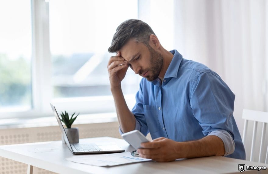 MoonPay review: a person looking at their phone, frustrated.