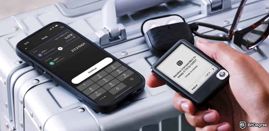 Multi-crypto wallet: a hand holds a Ledger Nano Gen 5 next to a smartphone displaying a crypto swap screen for ETH and USDT. Multi-crypto wallet: a hand holds a Ledger Nano Gen 5 next to a smartphone displaying a crypto swap screen for ETH and USDT.