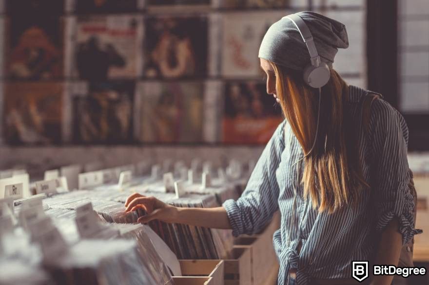 NFT Music: A woman wearing a hat examines a collection of music albums