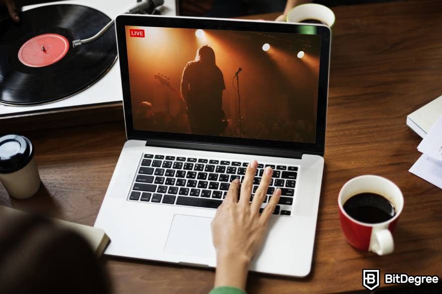 NFT Music:  A person watching an online concert on a laptop screen