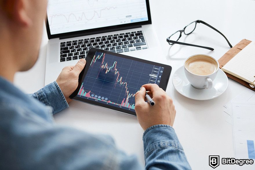 Notcoin Bybit: a person holding a mobile tablet displaying price chart.