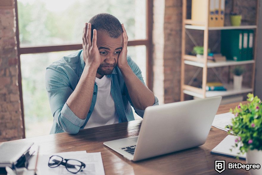 Notcoin Bybit: a person looking frustrated while looking at a laptop.