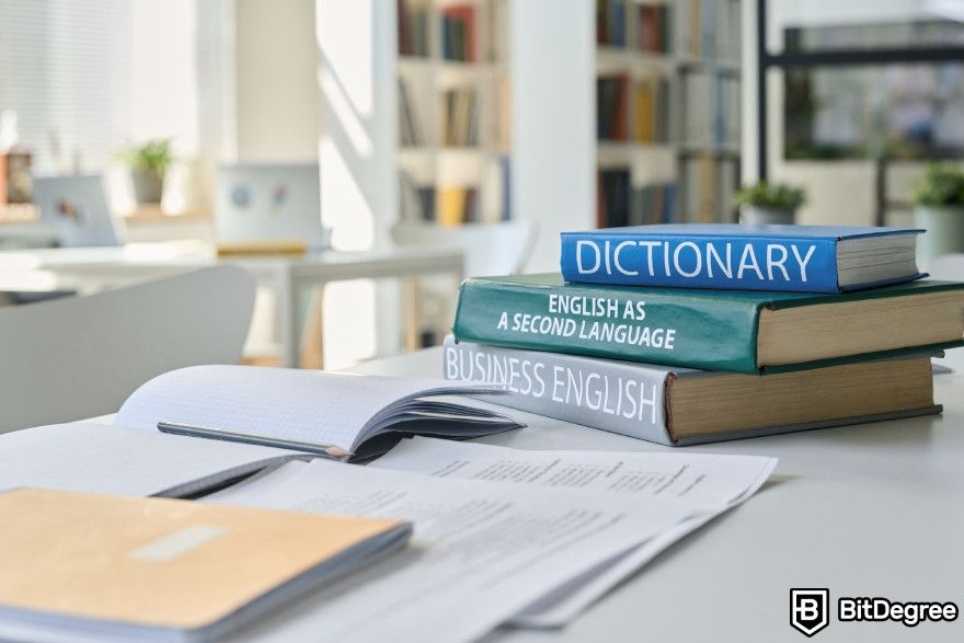 Otter.ai review: Dictionary and other books on a table.