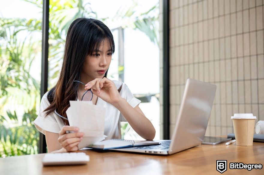 Polygon blockchain: businesswoman working on her laptop and documents at a coffee shop.