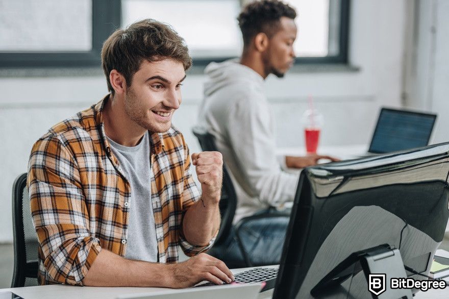 Polygon blockchain: a happy developer looking at a monitor.