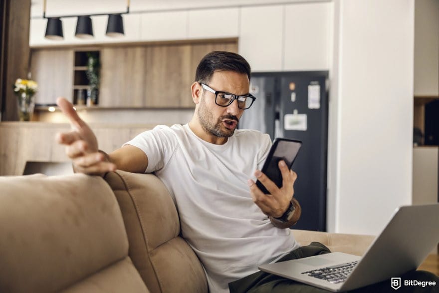 Polymarket review: a person looking at a mobile phone looking frustrated.
