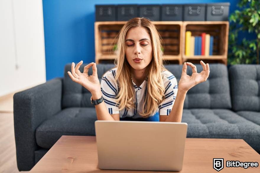 Pump and dump crypto: A woman on a couch breathing in front of a laptop