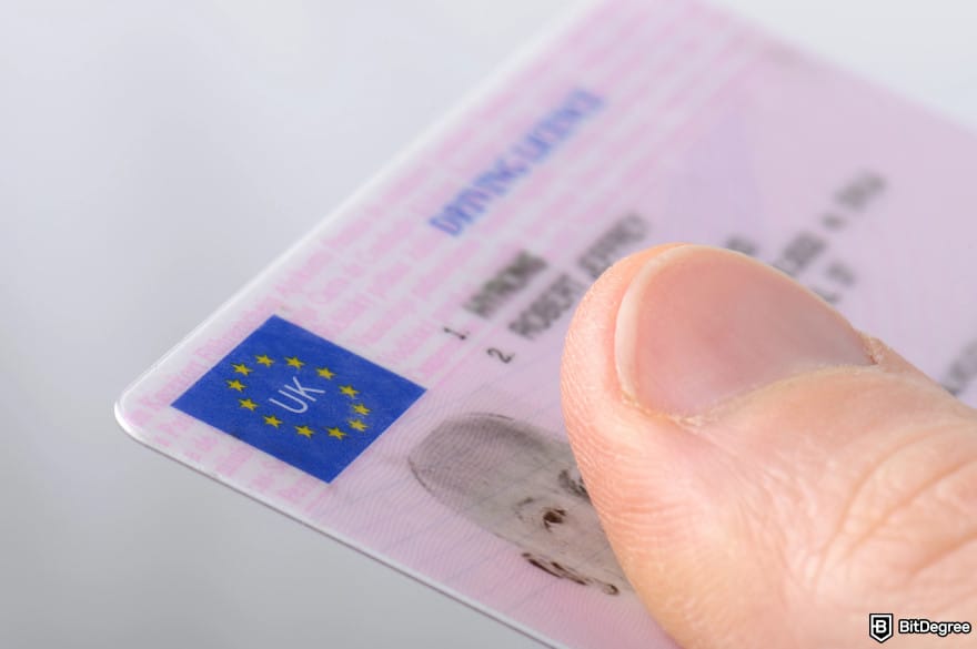 Safest crypto exchange: a UK driving license held by a thumb.