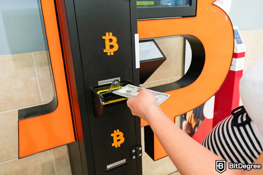 Should I buy Bitcoin: A person using a Bitcoin ATM.