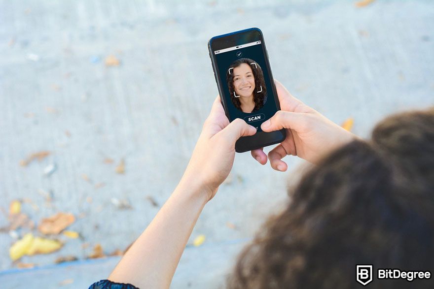 Soft token: a person using their face to unlock a smartphone.