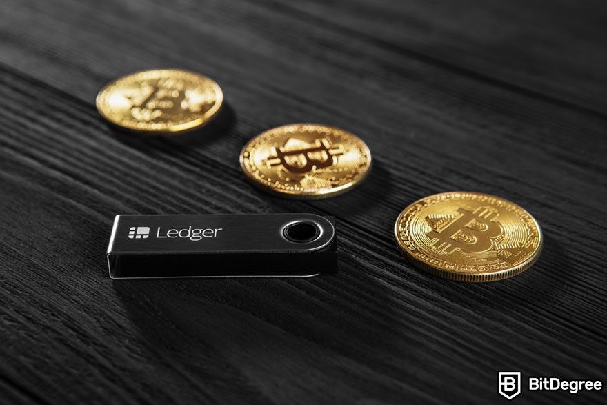 Staking crypto: Ledger hardware wallet with three Bitcoin tokens.