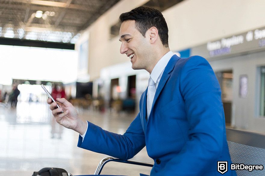 Top security tokens crypto: a person using mobile phone while smiling.