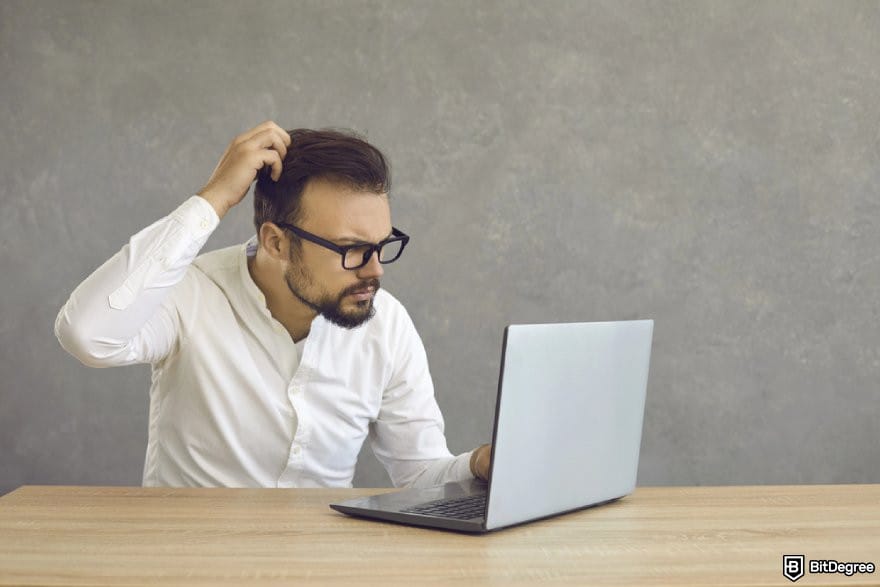 Uphold review: a person looking at a laptop, looking confused.