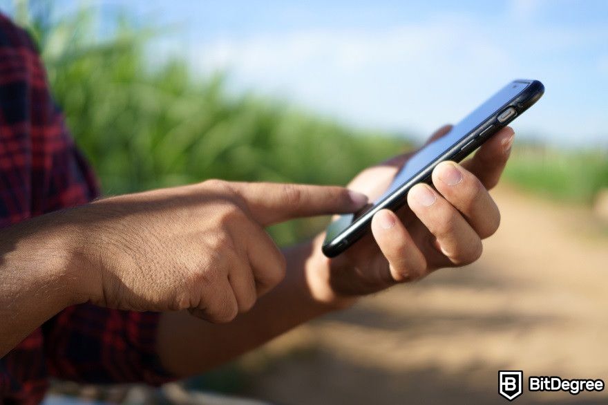 Virtual currency: A man holding a phone in a farm.