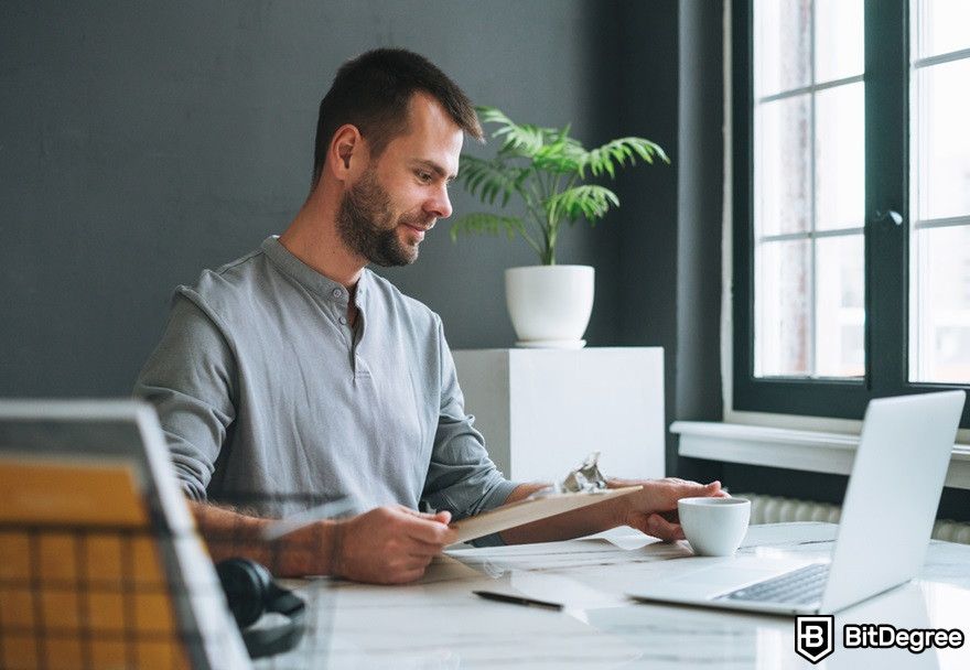 What is AMP crypto?: A young smiling businessman looking at a laptop.