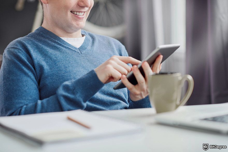 What is Hedera: a person using a mobile tablet while smiling.