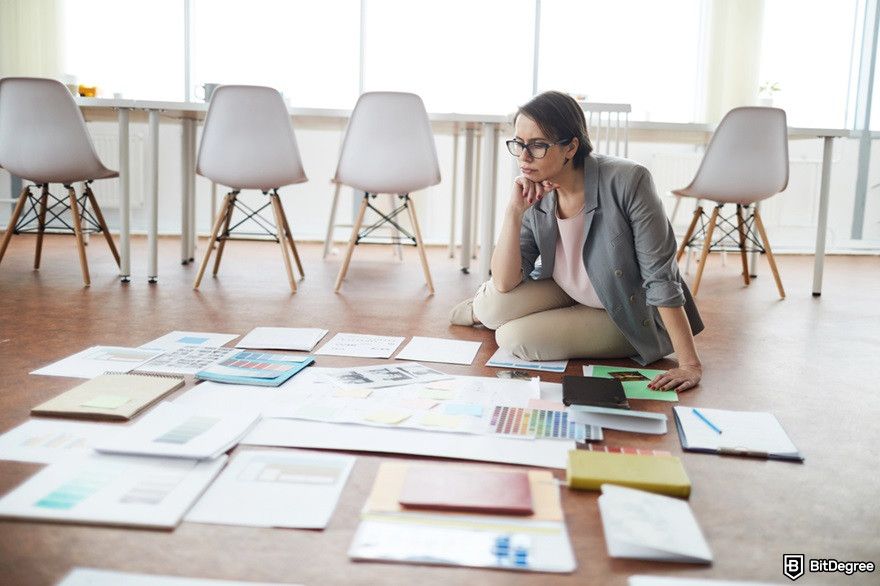 What is Hosky token: a woman sitting on the floor and planning a project.