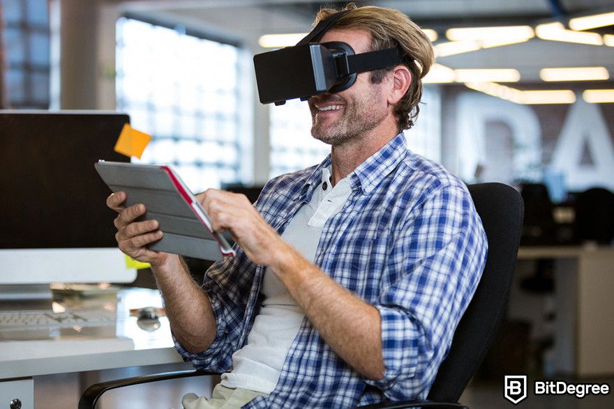 What is Render crypto: a person holding a tablet while wearing a VR headset.