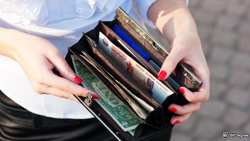 WorldRemit review: a person shows purse with different currencies. WorldRemit review: a person shows purse with different currencies.