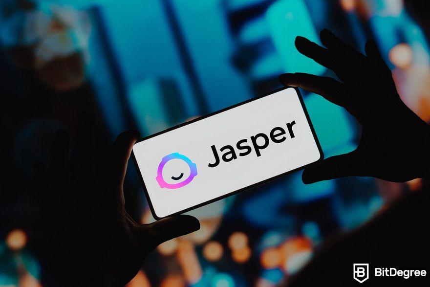 Writesonic review: Jasper logo on phone screen.