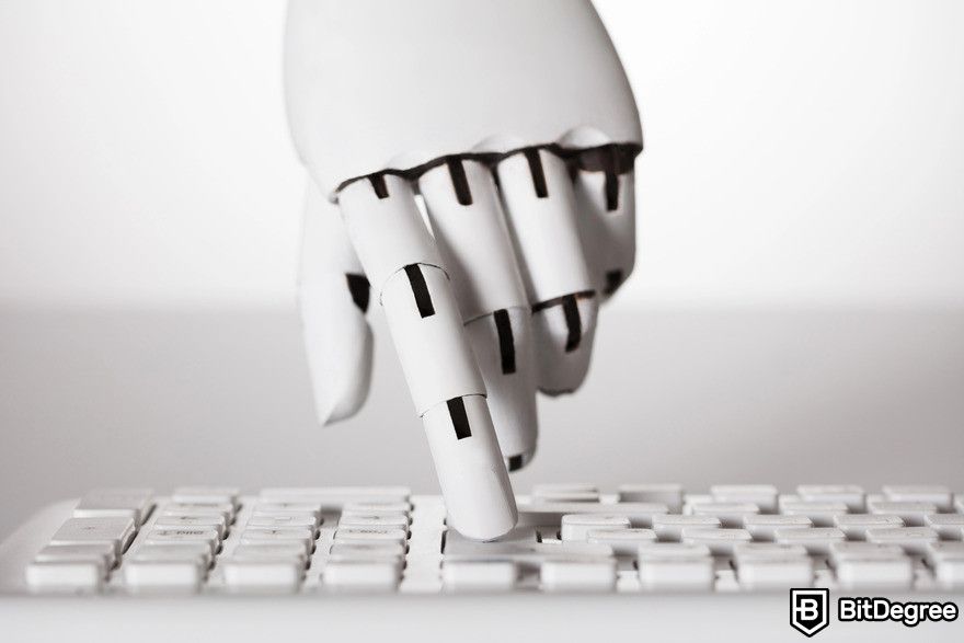 Writesonic review: robot hand typing on keyboard.