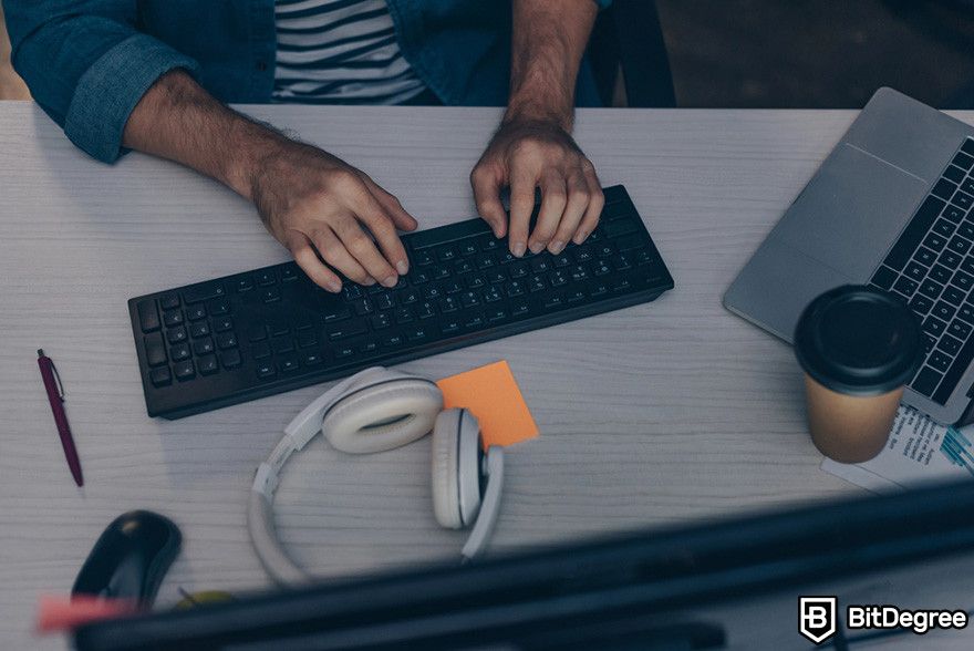 Zero knowledge proof: a person using a desktop computer with a laptop at their side.