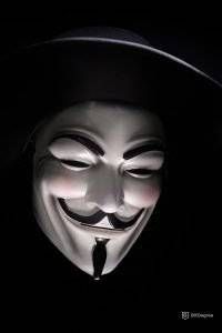 A hacker wearing an Anonymous mask 