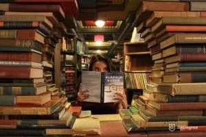 JavaScript библиотеки: девушка в окружении книг.