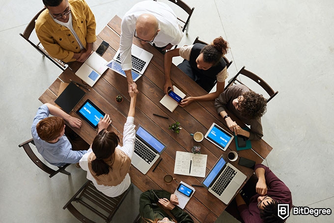 Best online coding courses: a group of people around the table.