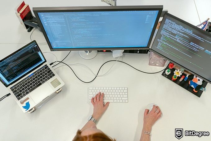 Best online coding courses: a woman looking at her computer screens.